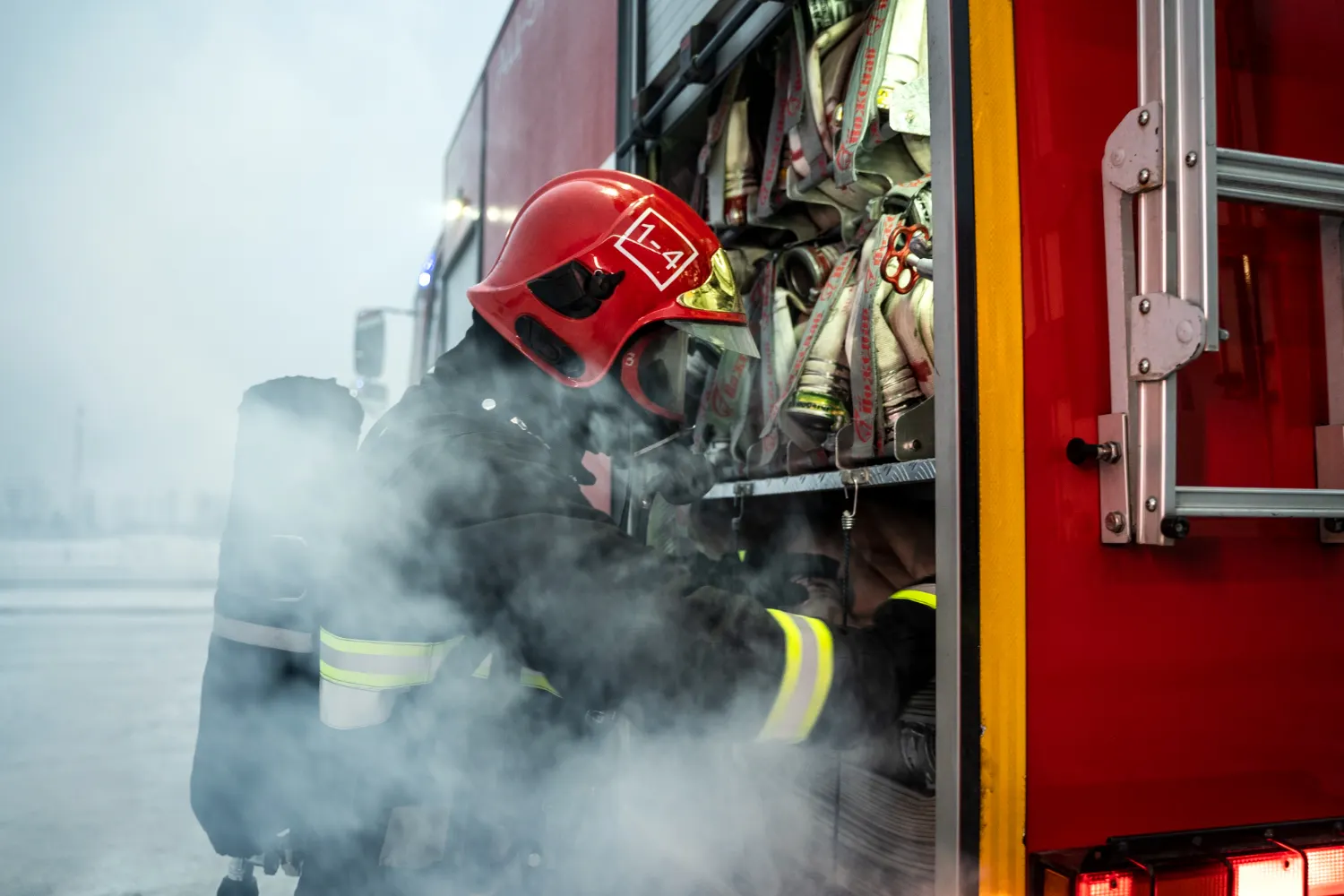 Empresa de bomberos en acción, bombero preparándose para operación.