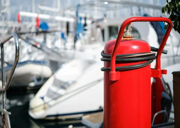 gep-services-primer-plano-del-extintor-de-incendios-en-el-amarre-del-club-nautico-fondo-borroso-que-proporciona-proteccion-contra-incendios-y-prevencion-de-seguridad -